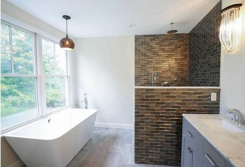 Bathroom with a freestanding tub and dark brick accent wall
